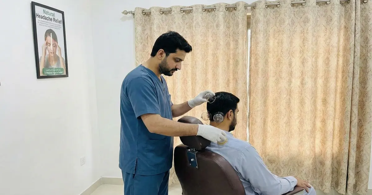 Hijama therapist performing cupping for migraine relief at Al Madinah Hijama Center Lahore.